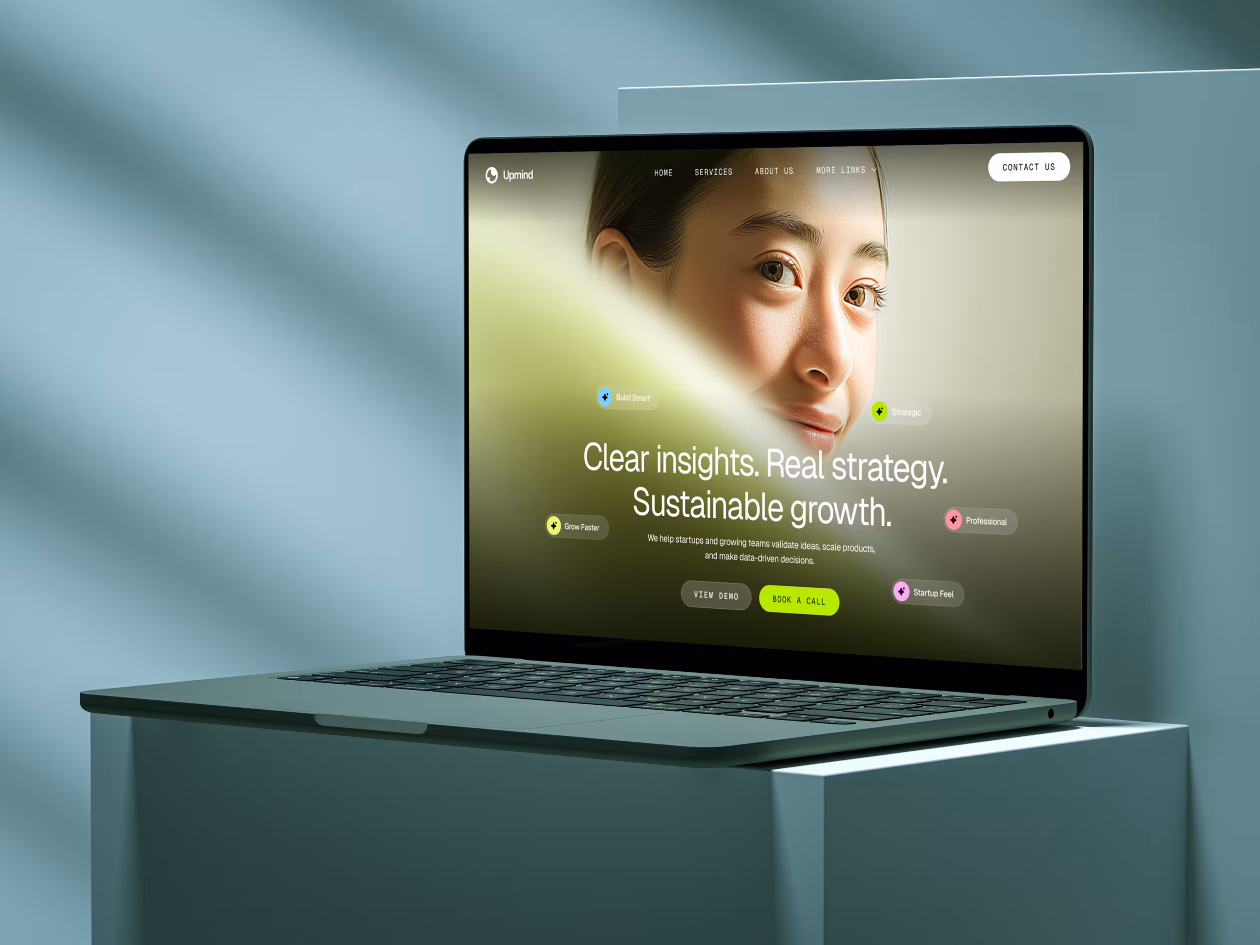 Mockup de um notebook exibindo o site de uma consultoria empresarial, sobre um bloco em tom azul-esverdeado