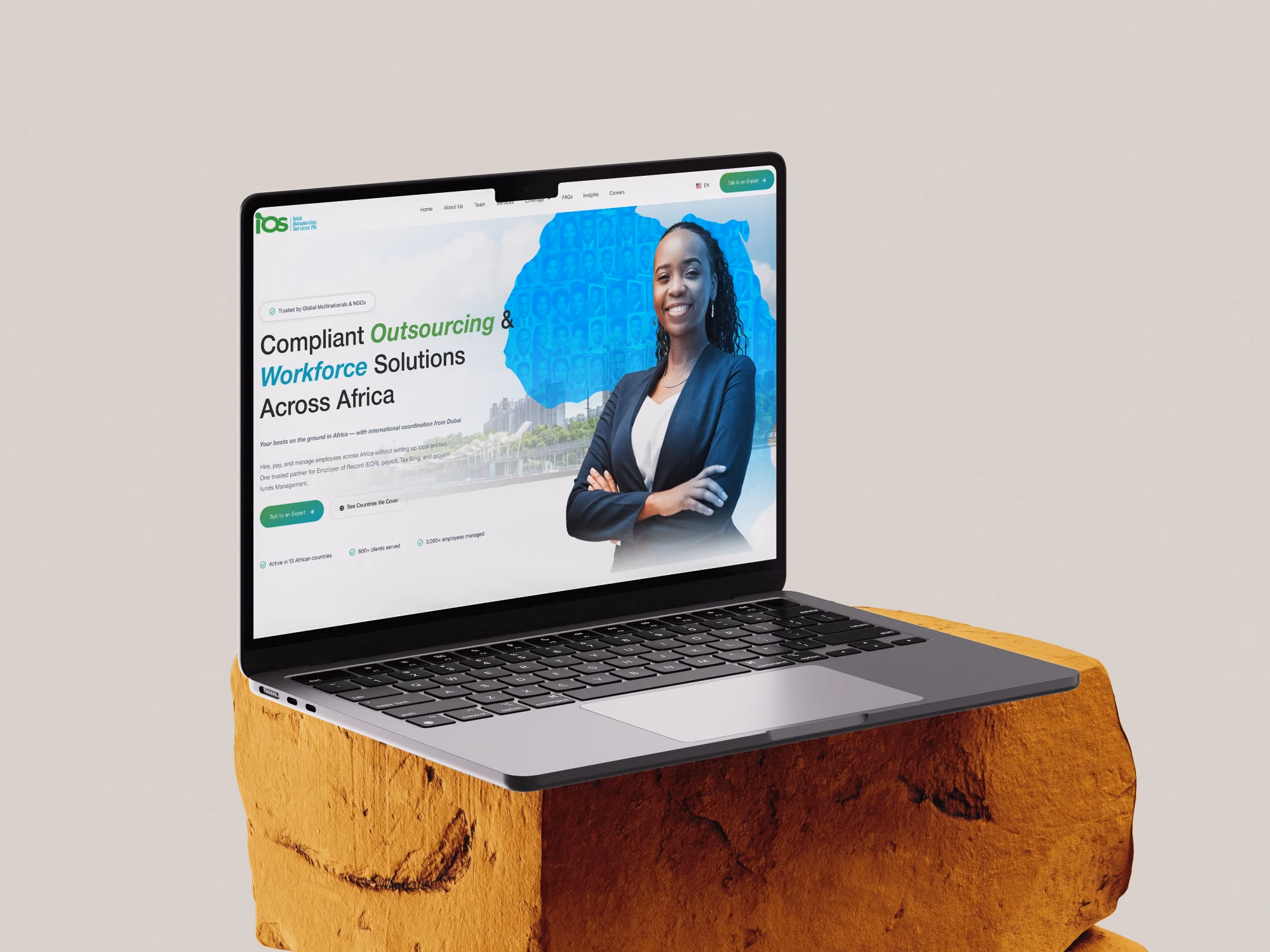 Mockup de um notebook exibindo o site de uma empresa de outsourcing e RH, apoiado sobre uma pedra